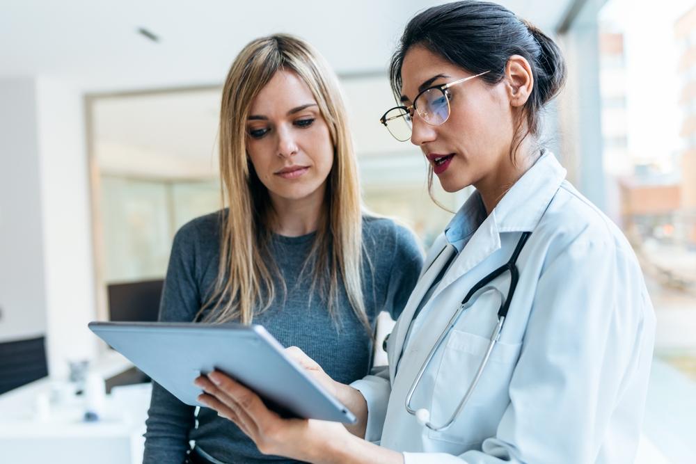 A patient discusses her pedestrian accident injuries with a doctor.